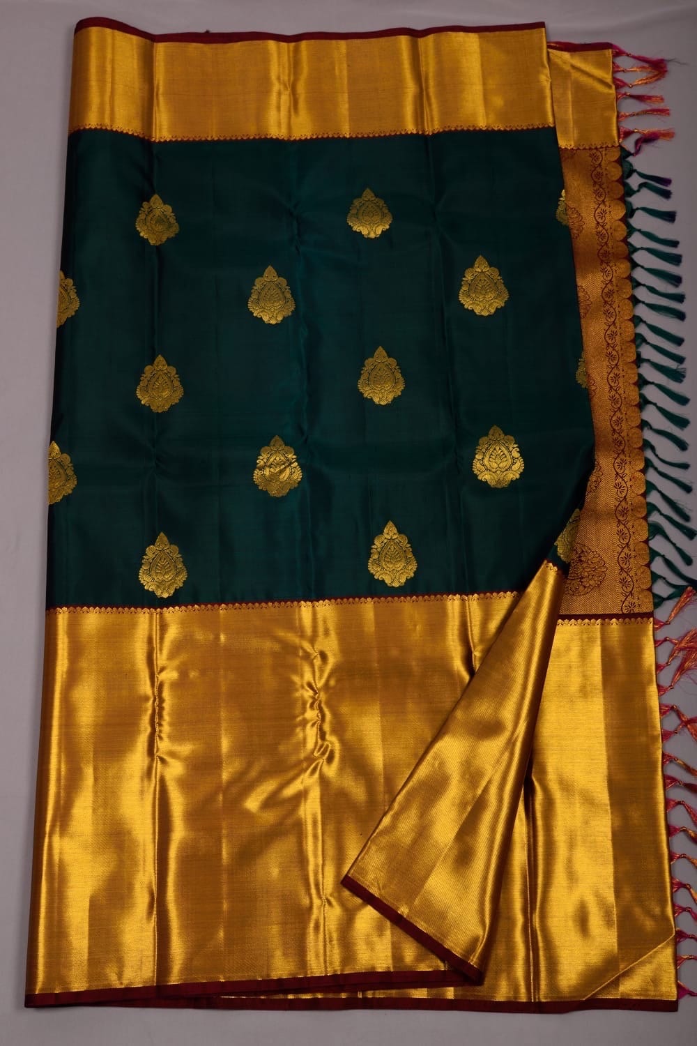 Pure silk Kanchipuram saree in bottle green with maroon colour combination and with beautiful thilagam butta ask seller before placing